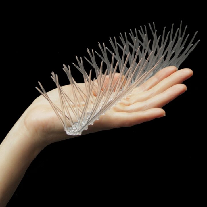 Defender® Thistle® Small Bird Spike being held in a hand - showing its size