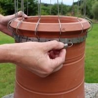 Defender® Chimney Pot Spikes being clipped into position on a round chimney pot